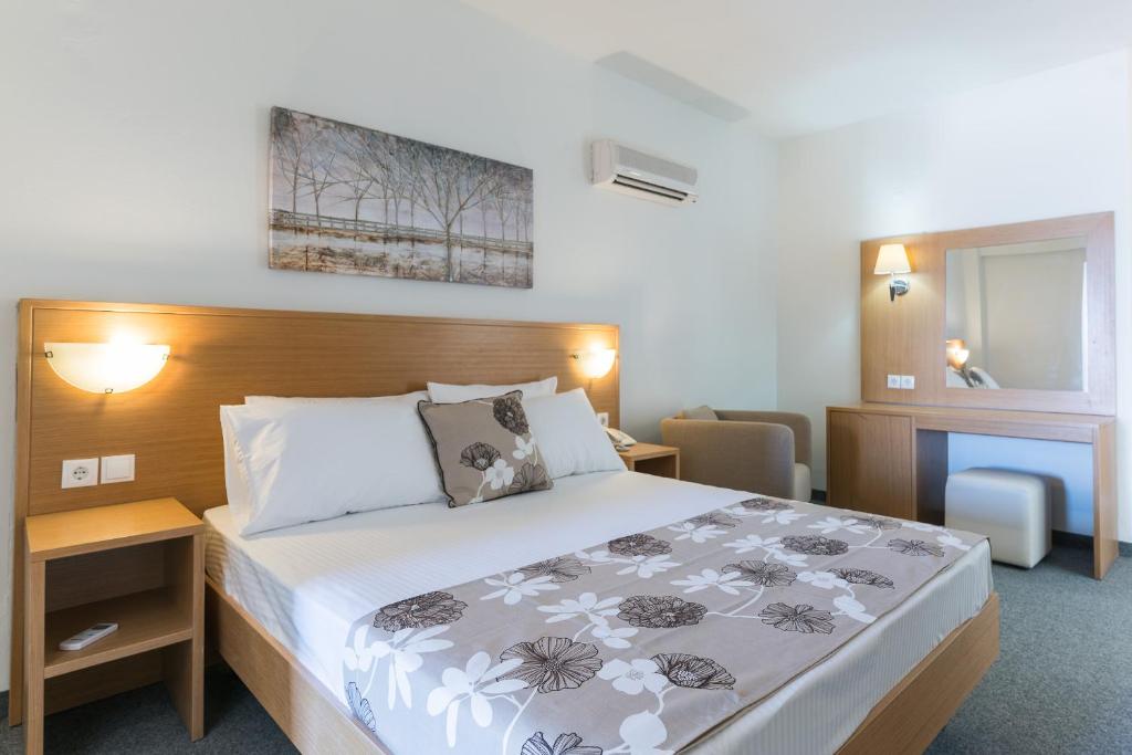 Mūsdienīgs viesnīcas numurs ar ērtu gultu, koka mēbelēm un mākslas darbu uz sienas, radot mierīgu atmosfēru. Ideāla izvēle relaksējošai atpūtai.