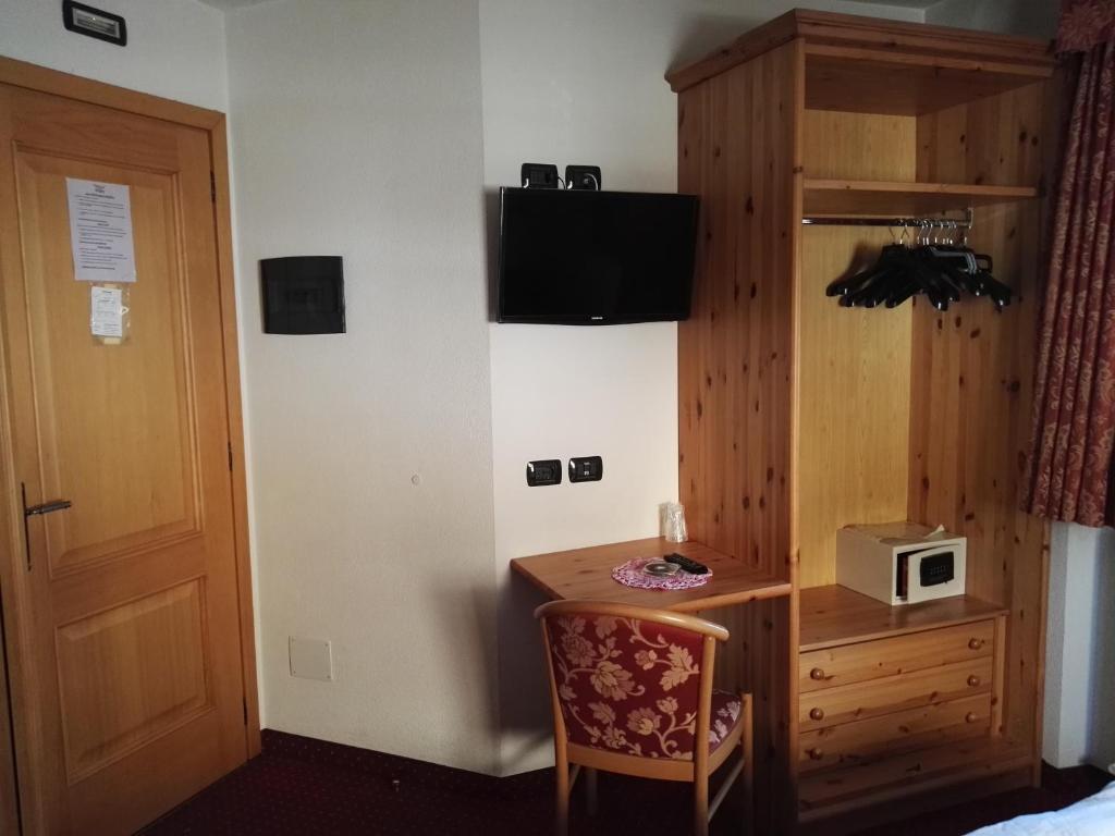 Kompakts viesnīcas numuriņš ar koka mēbelēm, TV, galdu un krēslu, kā arī drēbju skapi un seifu. Numurā ir arī durvis uz koridoru.