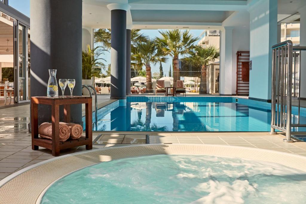 Relaksējoša peldbaseina un burbuļvannas zona ar palmām, koka galdu un dzērieniem. Ideāla vide atpūtai un relaksācijai spa.