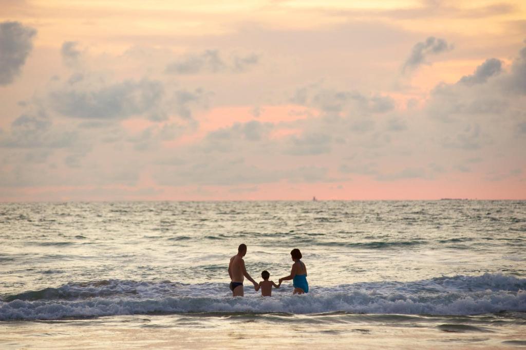 Ģimene, kas bauda viļņus pie Katathani Phuket Beach Resort