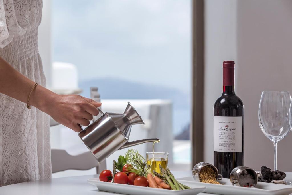 Eleganta galda iestatīšana ar sarkano vīnu, svaigiem dārzeņiem un olīveļļu, ko pasniedz pie jūras. Ideāla atmosfēra relaksējošai maltītei.
