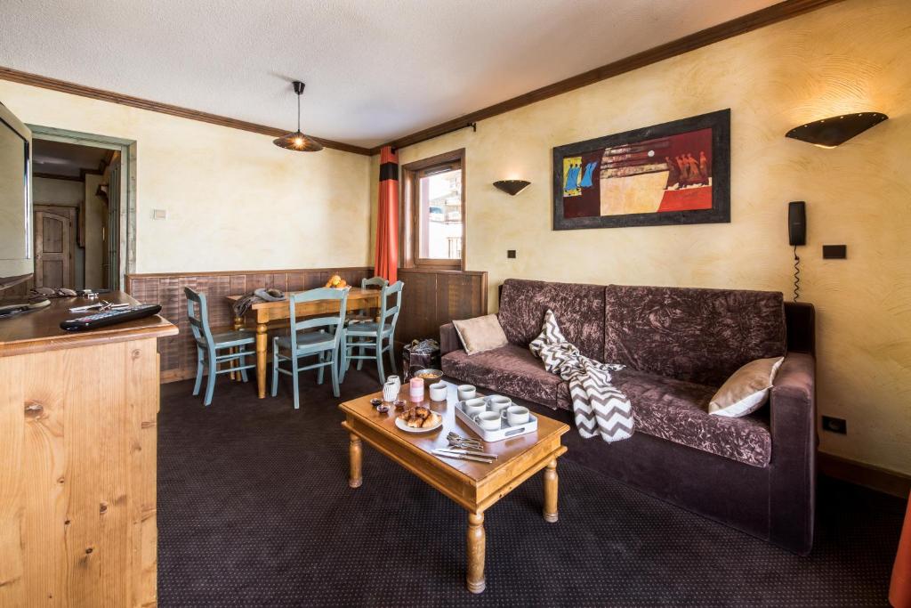 Mūsdienīgs viesnīcas numurs ar ērtu dīvānu, koka galdu un krēsliem, kā arī mākslas darbu uz sienas. Interjers ir siltās krāsās, radot mājīgu atmosfēru.