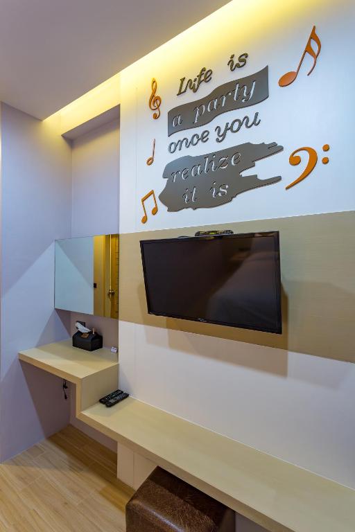 Mūsdienīgs interjers ar TV un rakstāmgaldu, uz sienas ir iedvesmojošs citāts 