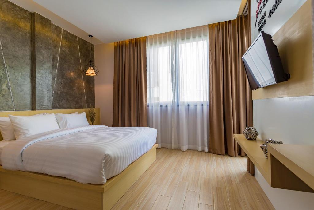 Moderns guļamistabas interjers ar gultu, atpūtas zonu un logiem, caur kuriem ieplūst dabiska gaisma. Interjeru raksturo neitrālas krāsas un eleganti elementi.