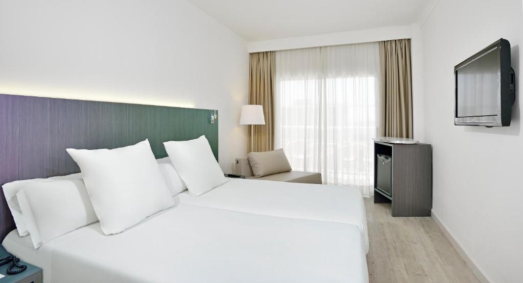 Mūsdienīgs viesnīcas numurs ar divām gultām, televizoru un logiem ar caurspīdīgām aizkariem, kas piedāvā dabīgu apgaismojumu. Numurs ir iekārtots neitrālās krāsās, radot relaksējošu atmosfēru.