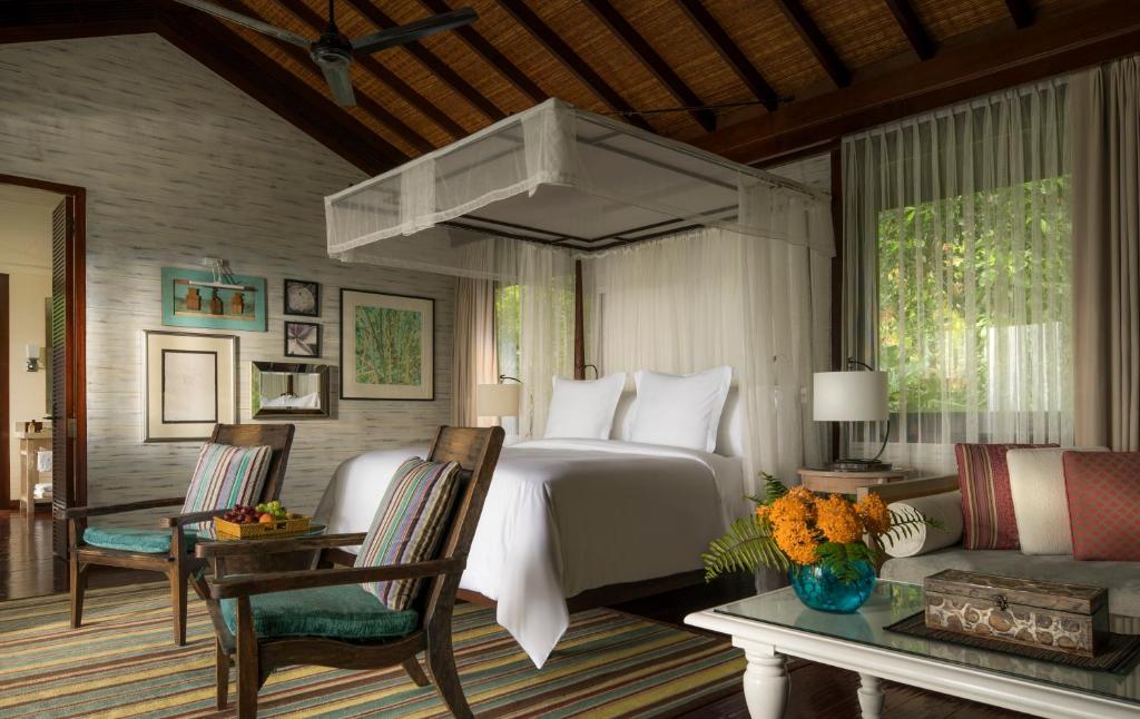 Four Seasons Resort Seychelles numurs ar baldahīna gultu un tropisku interjeru