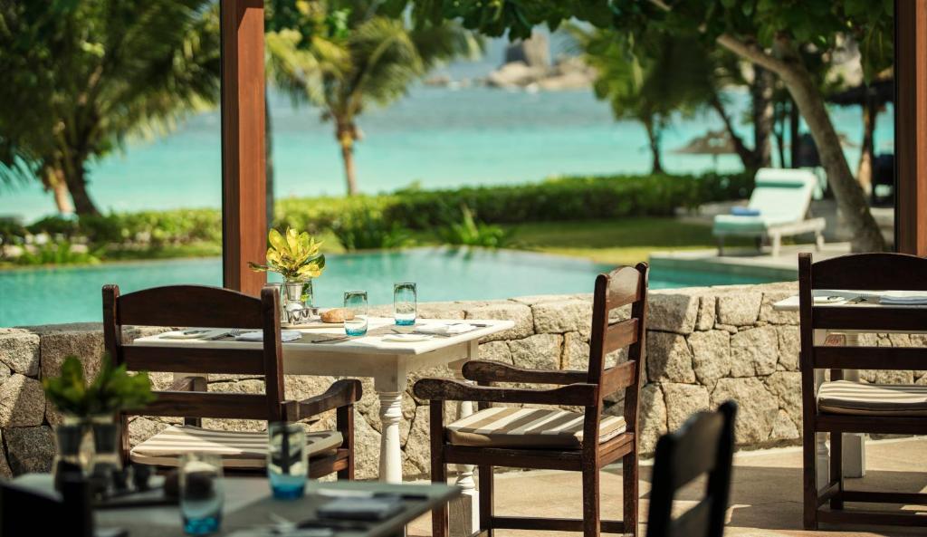 Four Seasons Resort Seychelles āra restorāna terase ar skatu uz baseinu un okeānu.