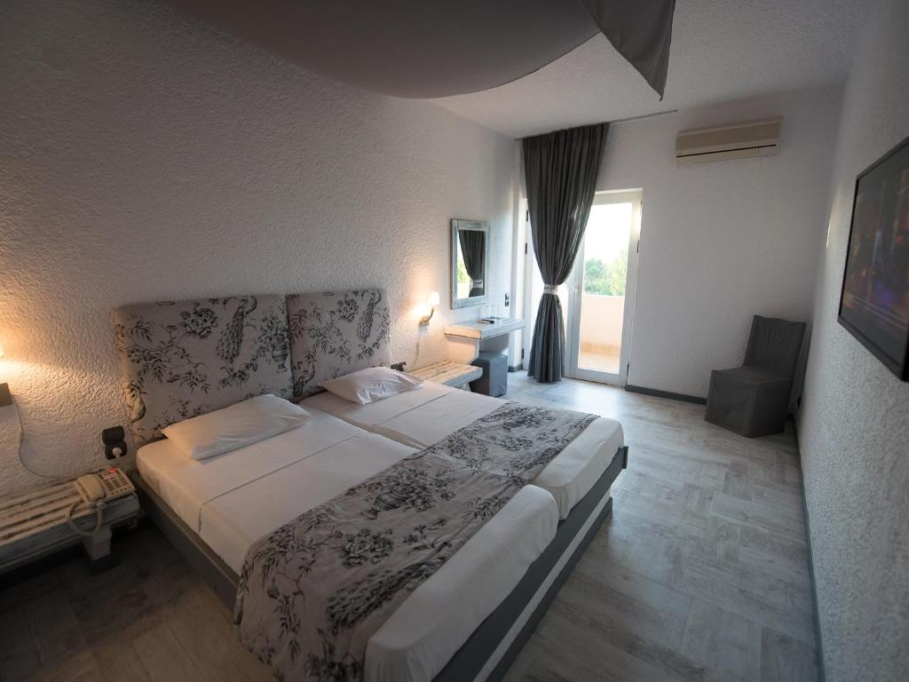 Mūsdienīgs viesnīcas numurs ar diviem gultām, dekorēts ar ziedu rakstu. Telpa ir gaiša un plaša, ar balkonu un ērtu sēdvietu.