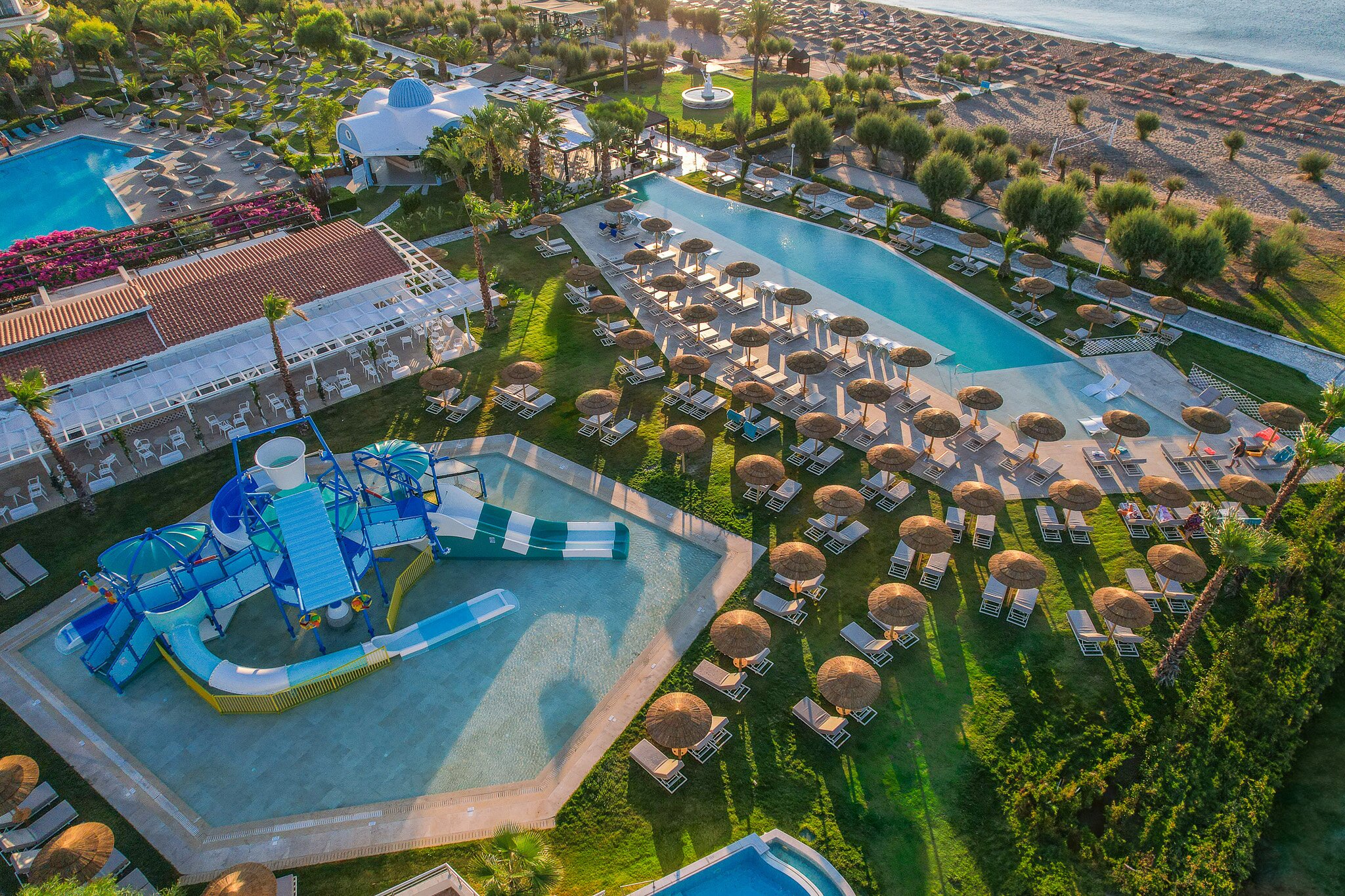 Pegasos Beach Hotel & Resort peldbaseins un ūdens slidkalniņš, sauļošanās krēsli panoramic view with beach and pools