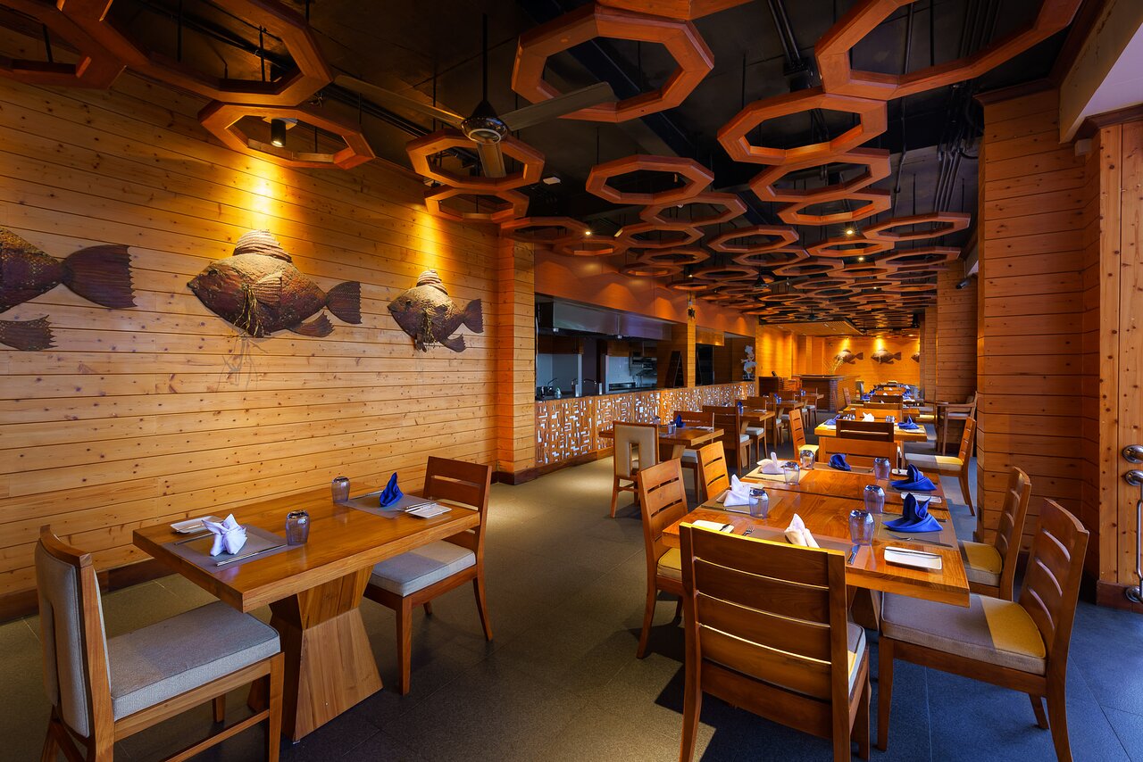 Araliya Beach Resort & Spa restorāns ar elegantu koka interjeru.