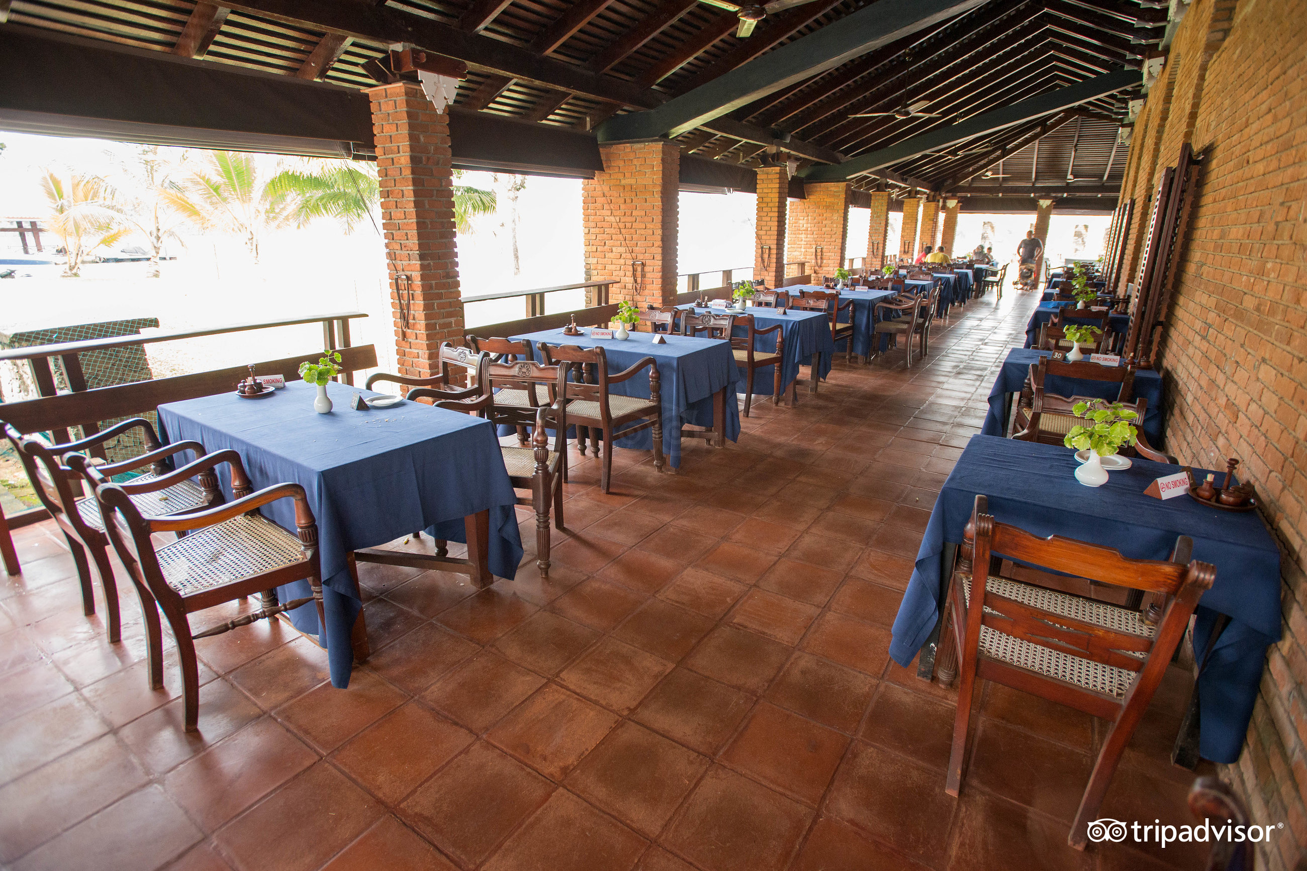 Club Bentota terase ar ēdamgaldiem un ķieģeļu sienām