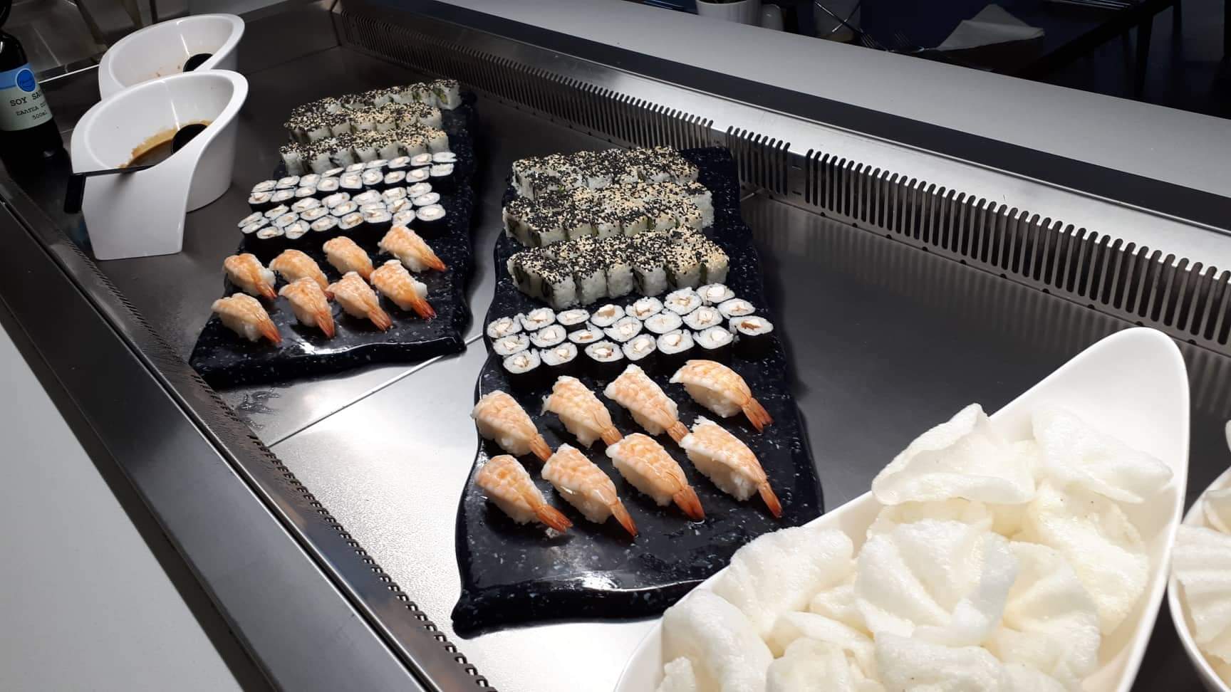 Pavlo Napa Beach Hotel bufetes restorāna suši izlase — dažādi maki un nigiri suši uz melnām paplātēm