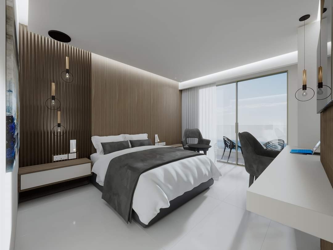 Pavlo Napa Beach Hotel dizaina numurs ar koka apdares sienu, modernu apgaismojumu un panorāmas logu uz terasi