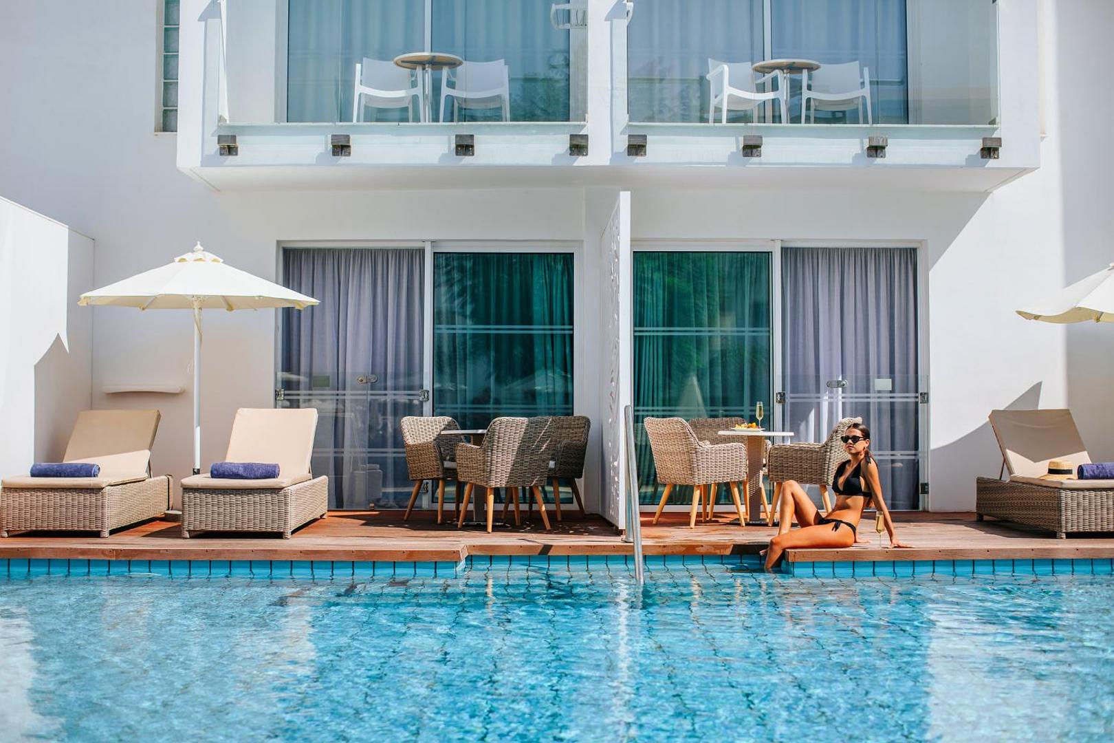 Sofianna Resort & Spa numurs ar tiešu piekļuvi baseinam — terase ar atpūtas krēsliem un saulessargu Pafas kūrortā