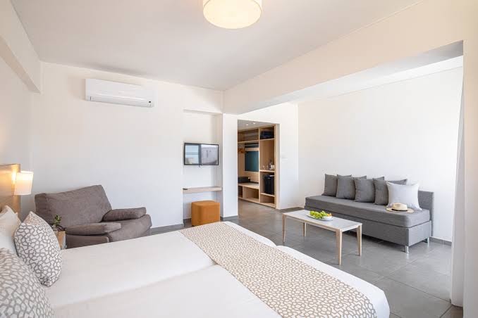 Sofianna Resort & Spa gaišs viesnīcas numurs ar divguļamo gultu, dīvānu, gaisa kondicionieri un ieeju garderobes zonā Kiprā