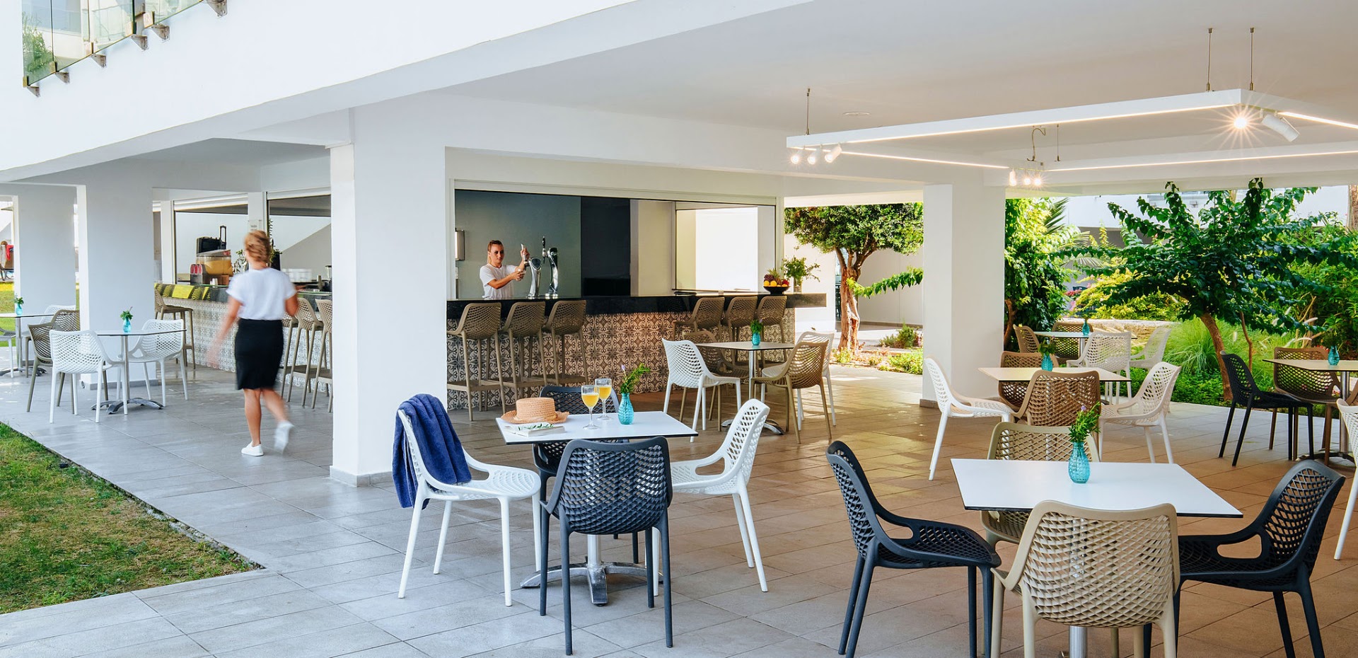 Sofianna Resort & Spa āra bārs un terase ar moderniem krēsliem un galdiņiem — gaiša atpūtas zona pie viesnīcas korpusa