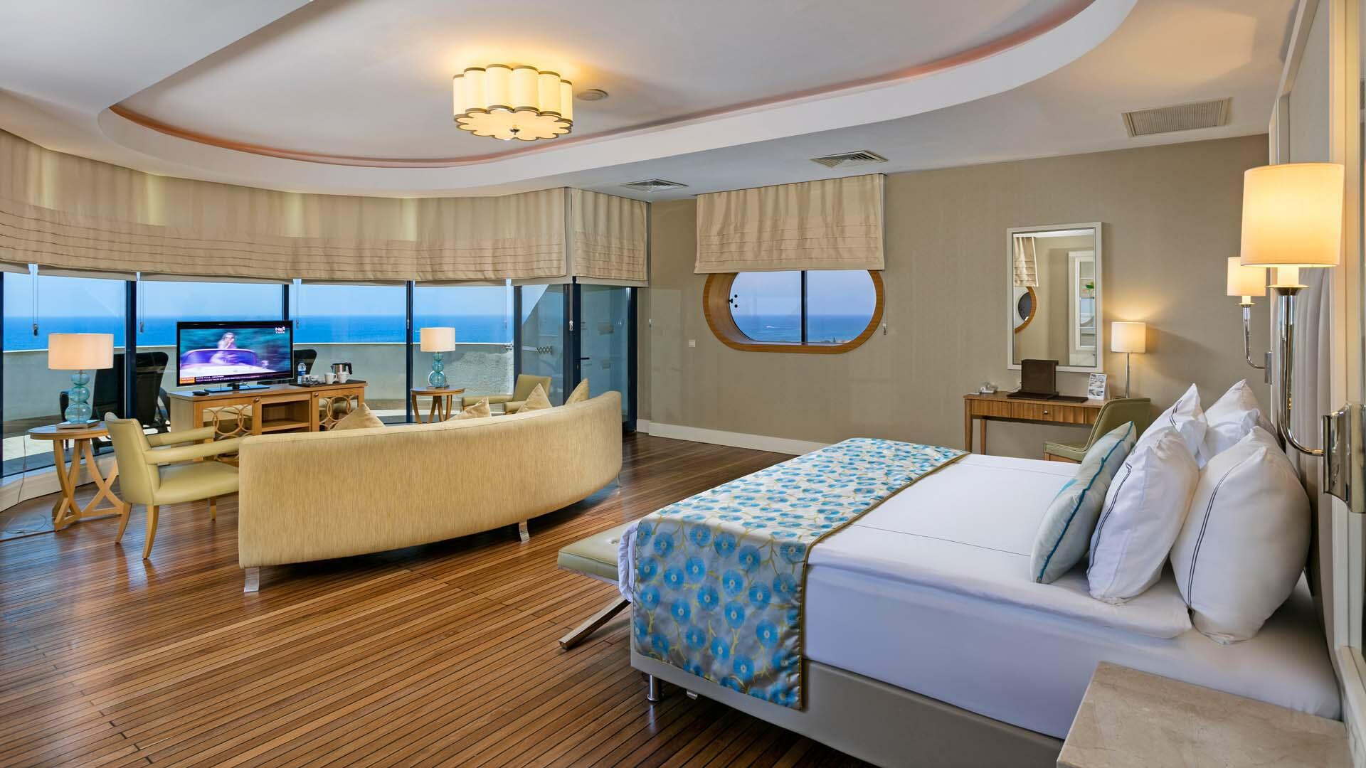 Plašs Titanic Deluxe Lara viesnīcas numurs ar koka grīdu, lielu gultu, dīvānu un panorāmas skatu uz jūru