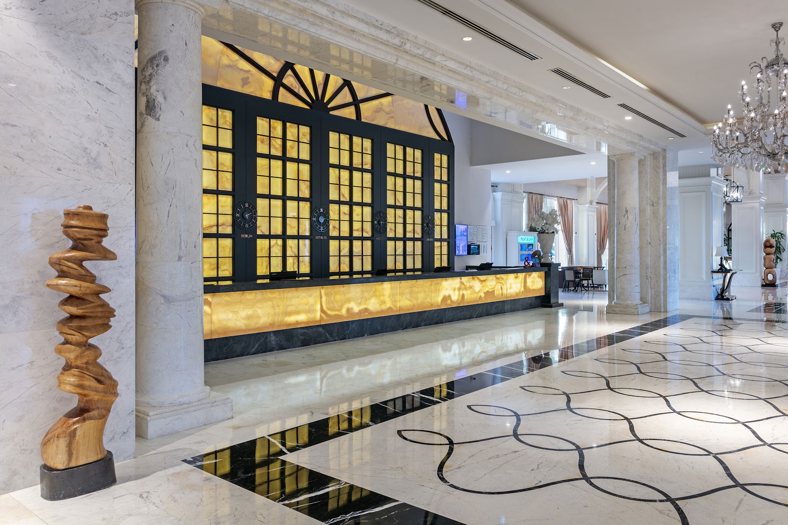 Titanic Deluxe Golf Belek greznais lobby un recepcijas zona ar marmora grīdām un izgaismotu leti Belekā, Turcijā