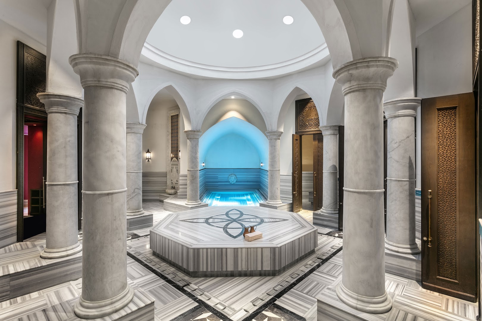 Titanic Deluxe Golf Belek spa centra tradicionālais turku hamams ar marmora kolonnām, kupola griestiem un centrālo akmens platformu relaksācijai Belekā