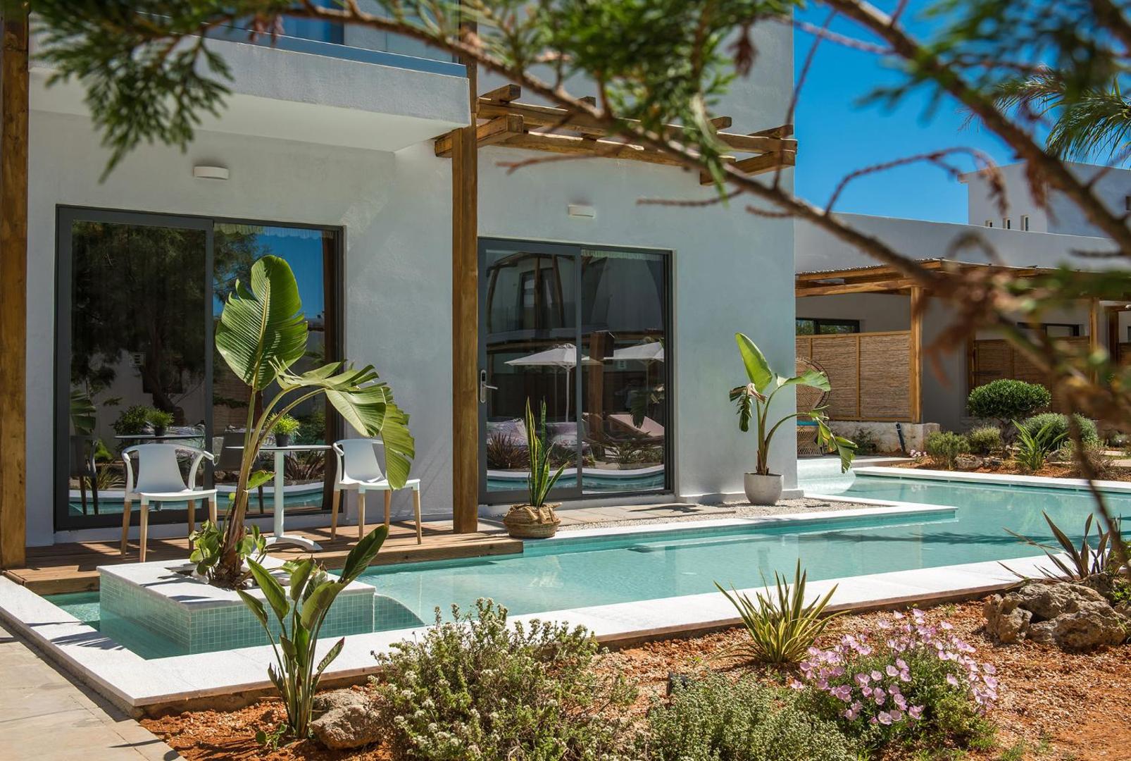Paralos Lifestyle Beach numurs ar tiešu piekļuvi baseinam no terases, ko ieskauj zaļi augi un koka elementi