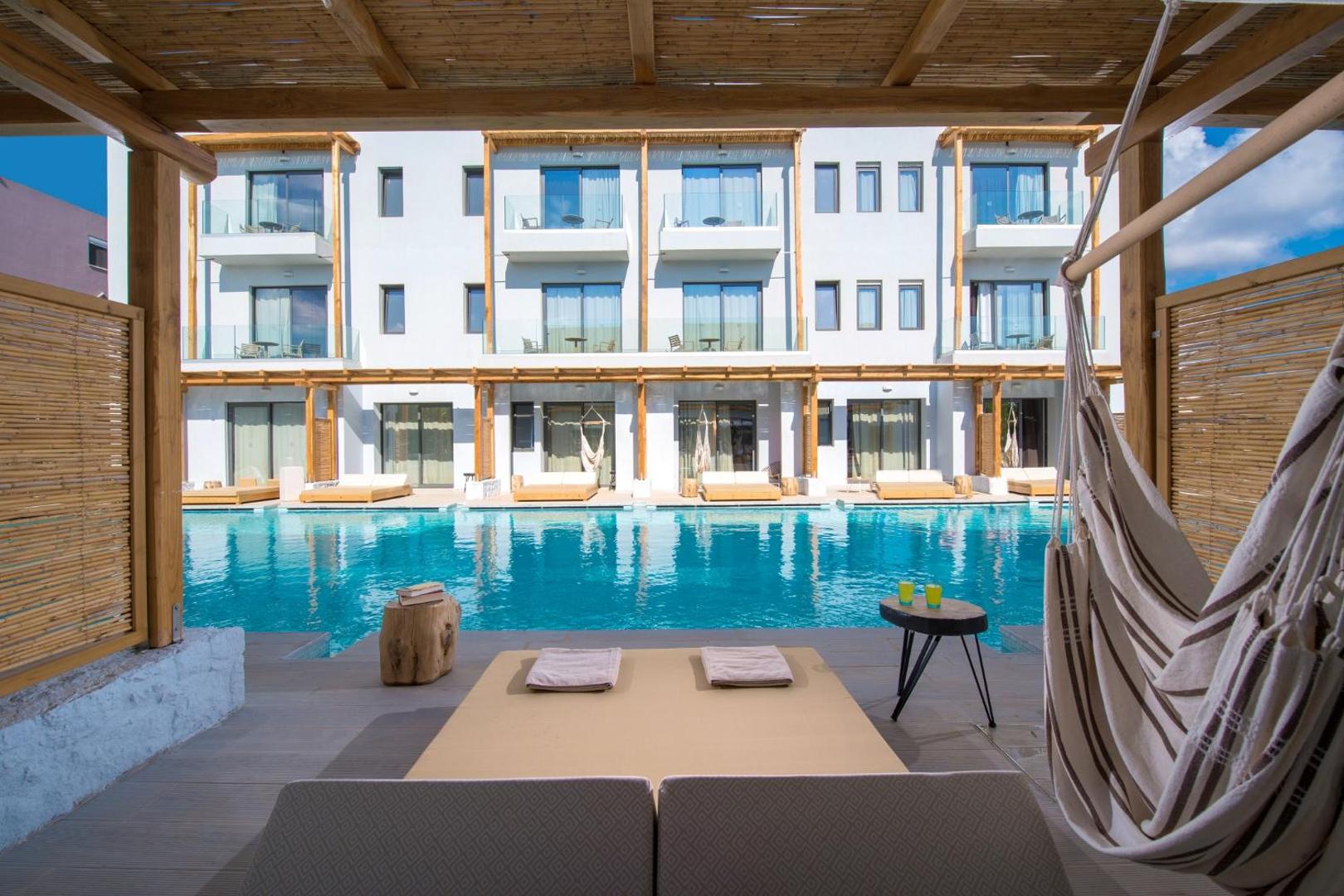 Skats no numura terases uz Paralos Lifestyle Beach koplietošanas baseinu un viesnīcas moderno fasādi
