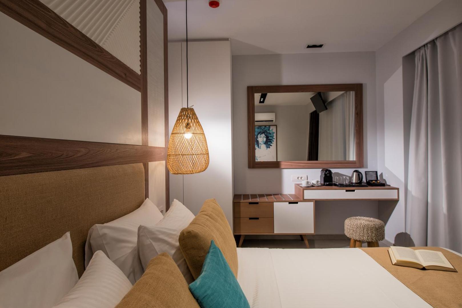 Paralos Lifestyle Beach numura detaļa ar darba virsmu, spoguli un tējas pagatavošanas piederumiem siltos koka toņos