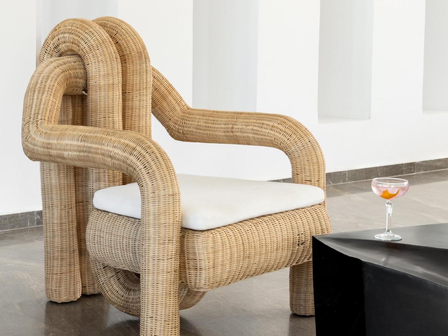 Grecotel Casa Adele dizaina atpūtas krēsls ar unikālu pītu pinumu un baltu spilvenu viesnīcas foajē vai atpūtas zonā