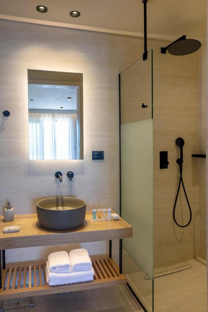 Atlantis Beach Hotel & Spa numura vannas istabas interjers ar koka elementiem, melnu dušas sistēmu un dizaina izlietni