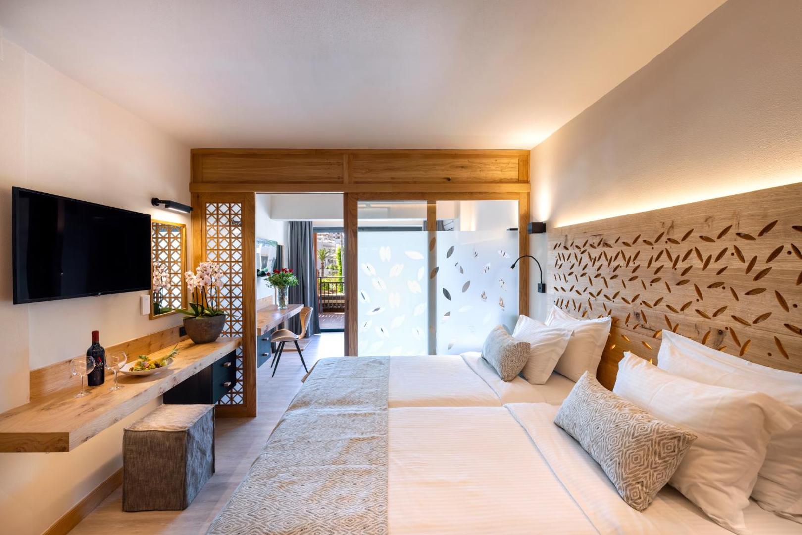 Atlantis Beach Hotel & Spa numurs ar dekoratīvu koka starpsienu, divām gultām un skatu uz balkonu