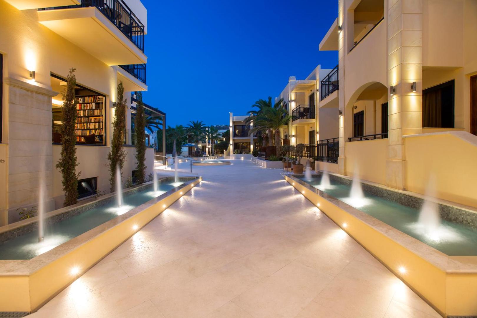 Atlantis Beach Hotel & Spa iekšpagalms ar dekoratīvām strūklakām un apgaismotām ejām starp viesnīcas korpusiem vakara stundā