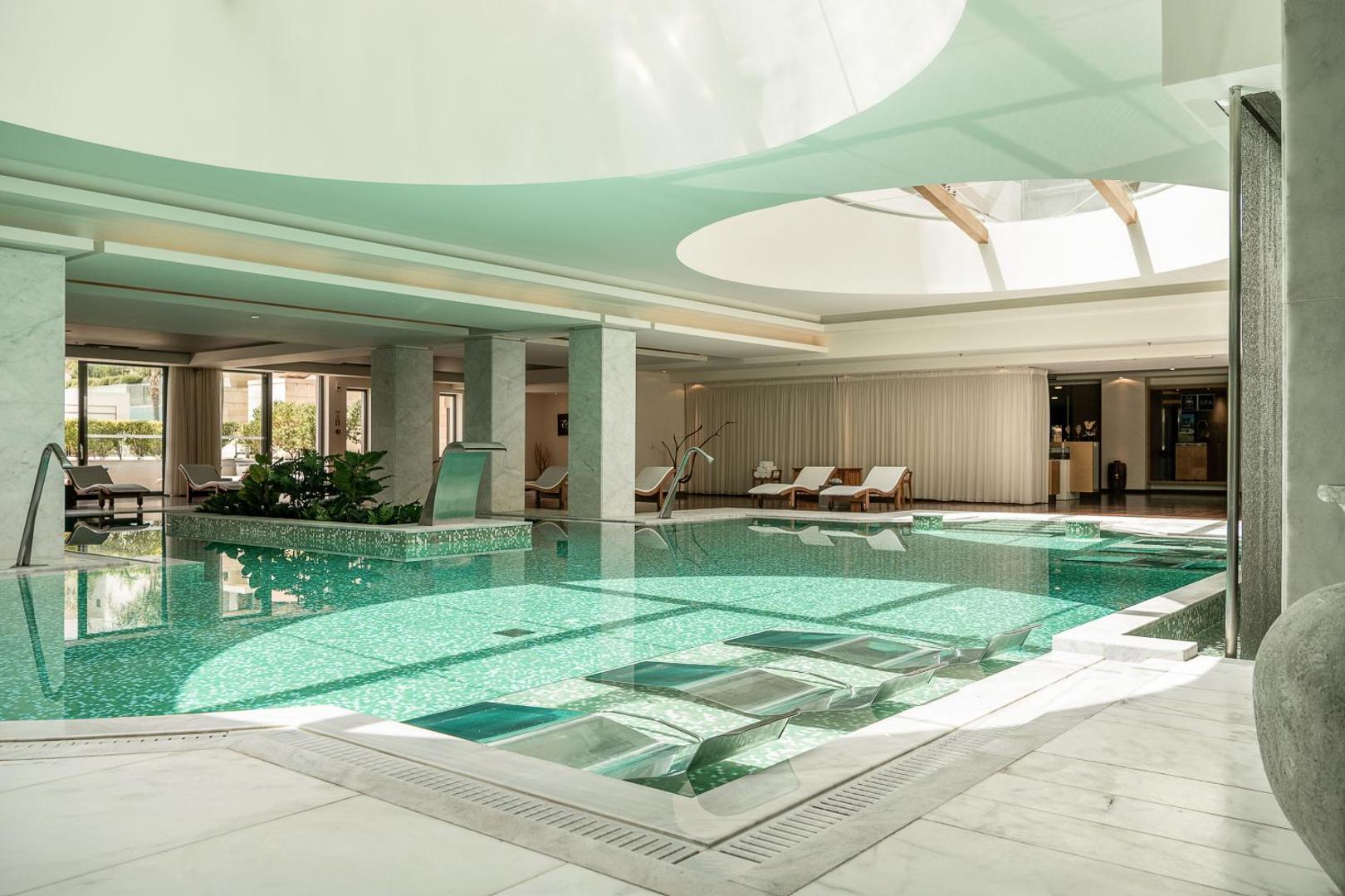 Avra Imperial Beach Resort iekštelpu spa baseins ar masāžas strūklām un sauļošanās krēsliem zem kupola