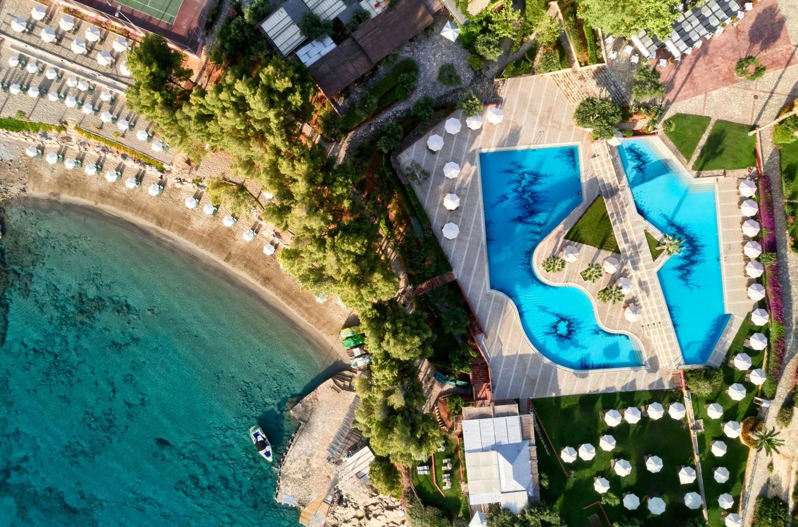 Candia Park Village skats no putna lidojuma uz zilo baseinu kompleksu, smilšu pludmali un tirkīza krāsas jūras līci Krētā