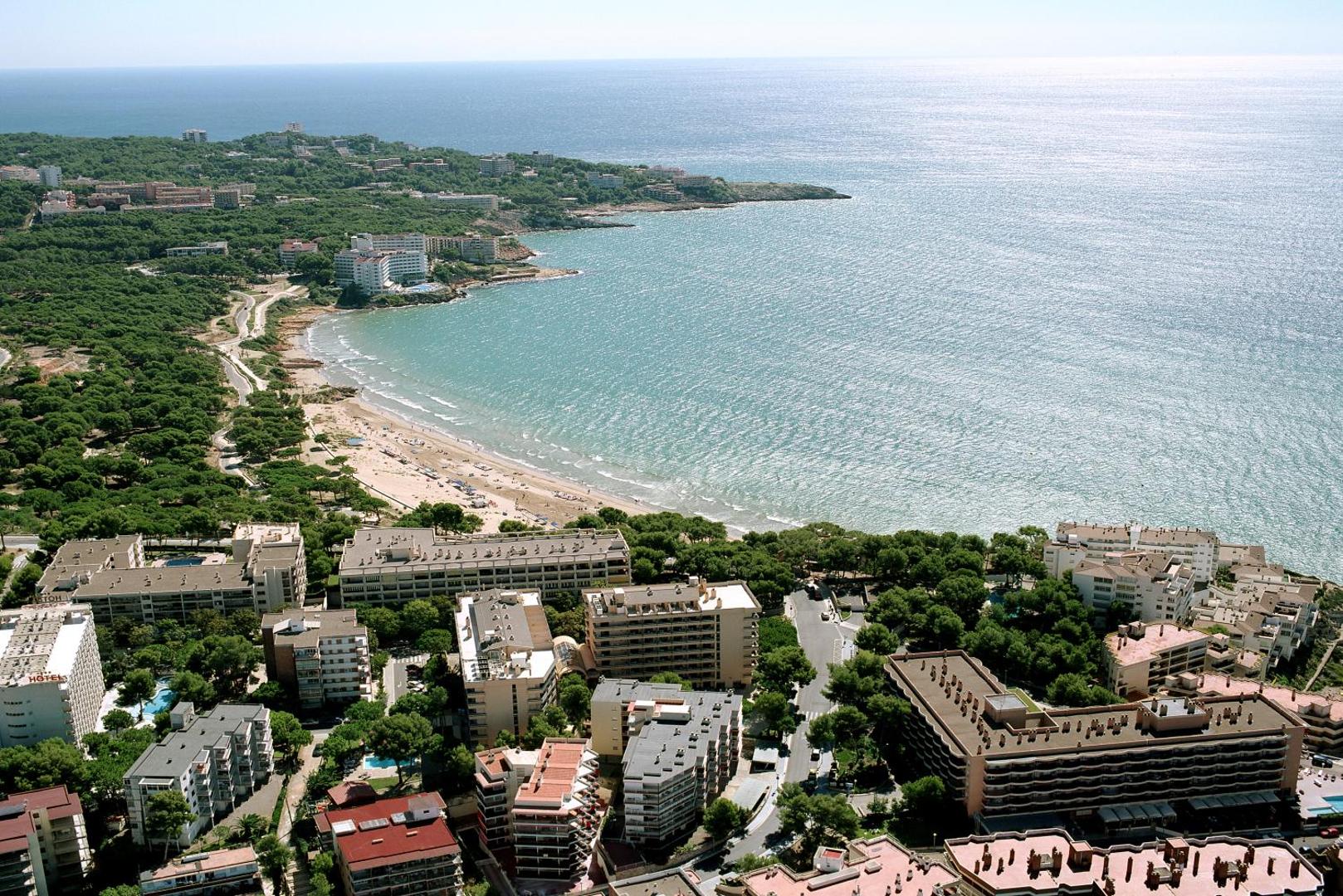 Aerofoto skats uz Salovas piekrasti un 4R Playa Park apkārtni — smilšu pludmale, zils jūras ūdens un pilsētas apbūve priežu ielokā.