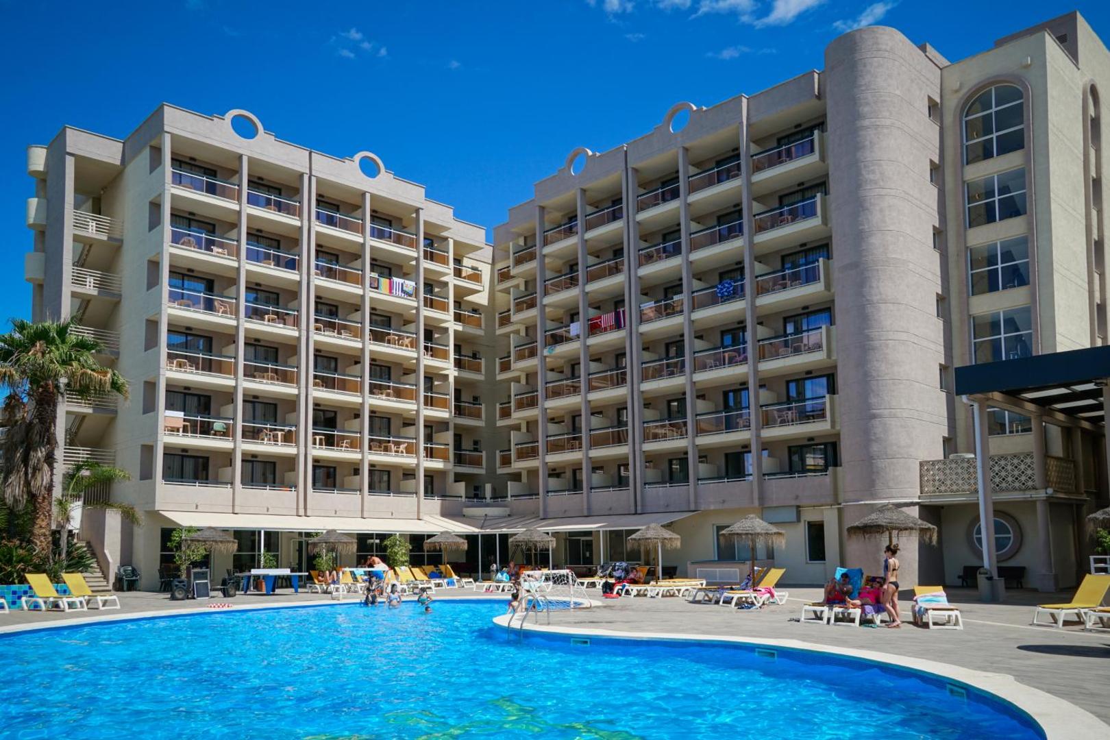 Ohtels Belvedere viesnīcas korpuss ar balkoniem un āra baseinu priekšplānā — saulaina diena Spānijas kūrortā Salovā.