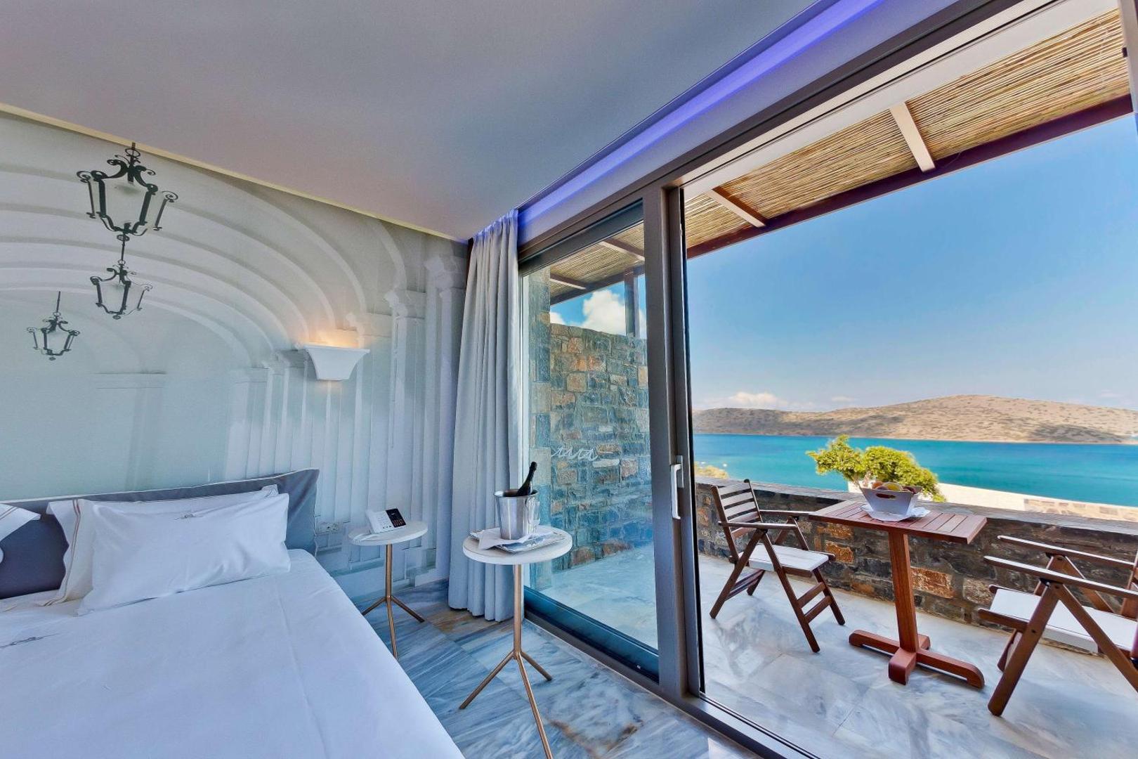 Royal Marmin Bay Boutique & Art Hotel dizaina numurs ar māksliniecisku sienu un izeju uz terasi ar skatu uz jūru