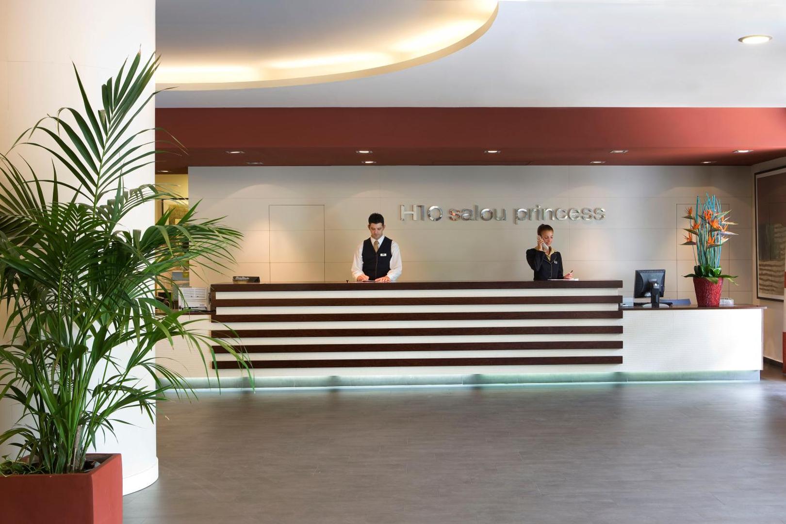 H10 Salou Princess viesnīcas recepcijas zona ar modernu reģistrācijas leti, personālu un viesmīlīgu atmosfēru Salovā