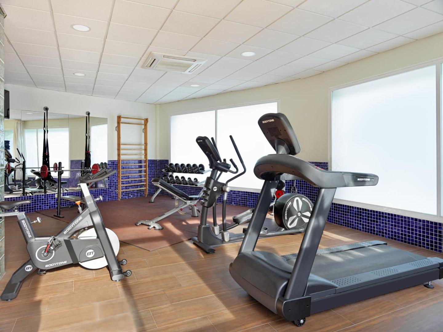 H10 Salou Princess fitness centrs ar trenažieriem — skrejceliņš, velotrenažieris un svaru bumbas gaišā telpā ar spoguļiem