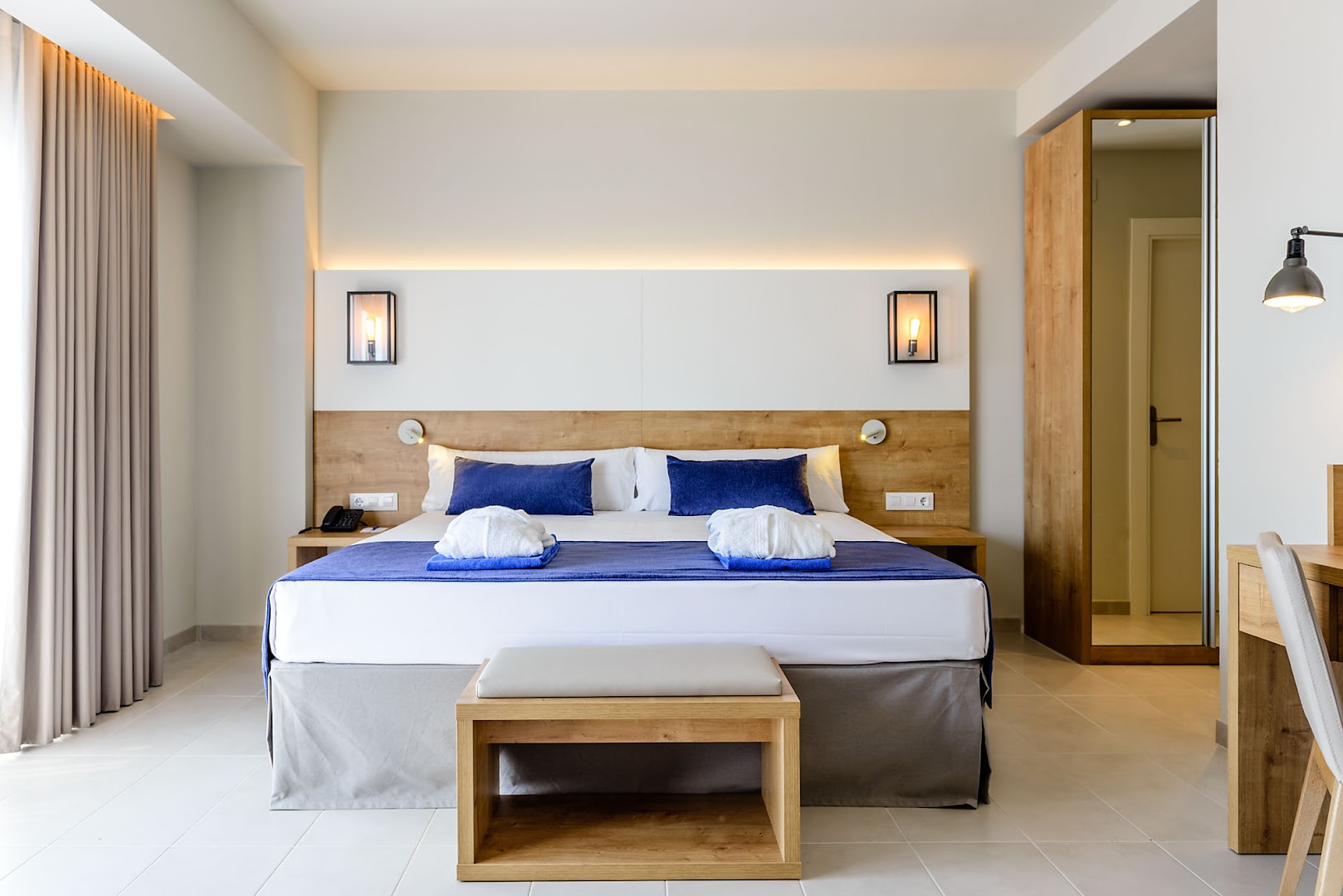 Estival Eldorado Resort moderns divvietīgs numurs ar koka apdari, gaišām flīžu grīdām un ziliem akcentiem gultas veļā Kostadoradā, Spānijā