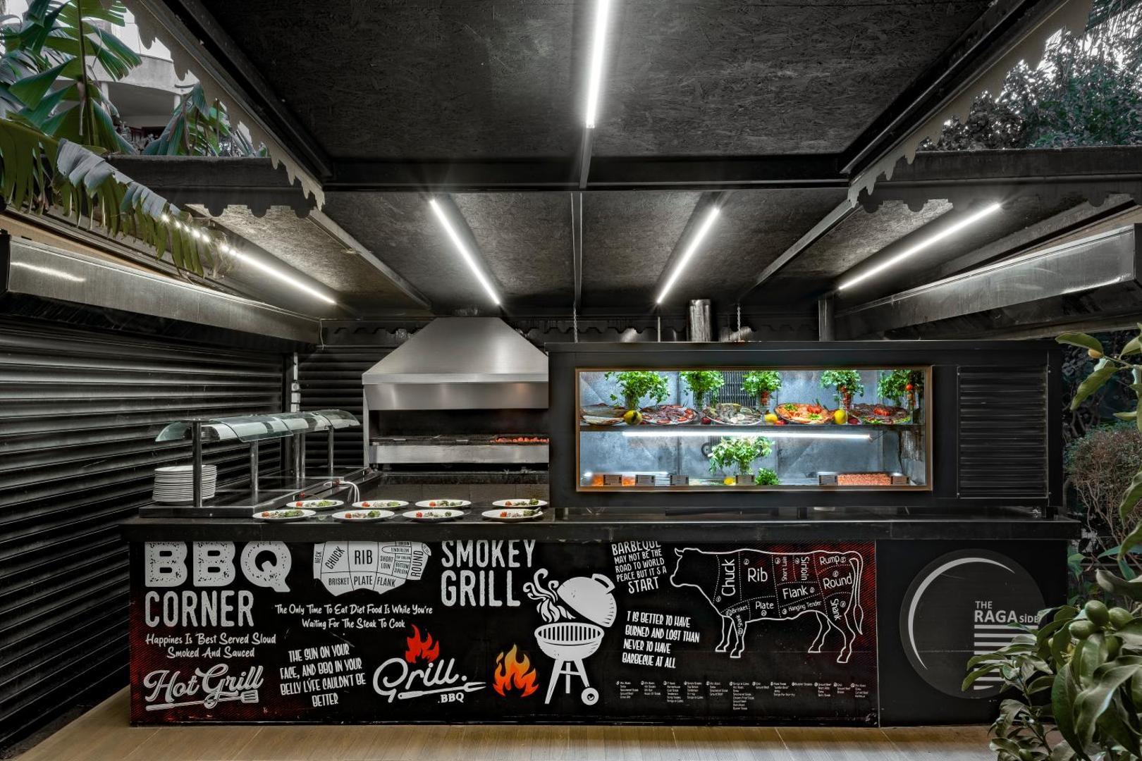 The Raga Side viesnīcas atvērtā tipa BBQ Corner grila zona ar modernu dizainu un svaigiem produktiem vitrīnā