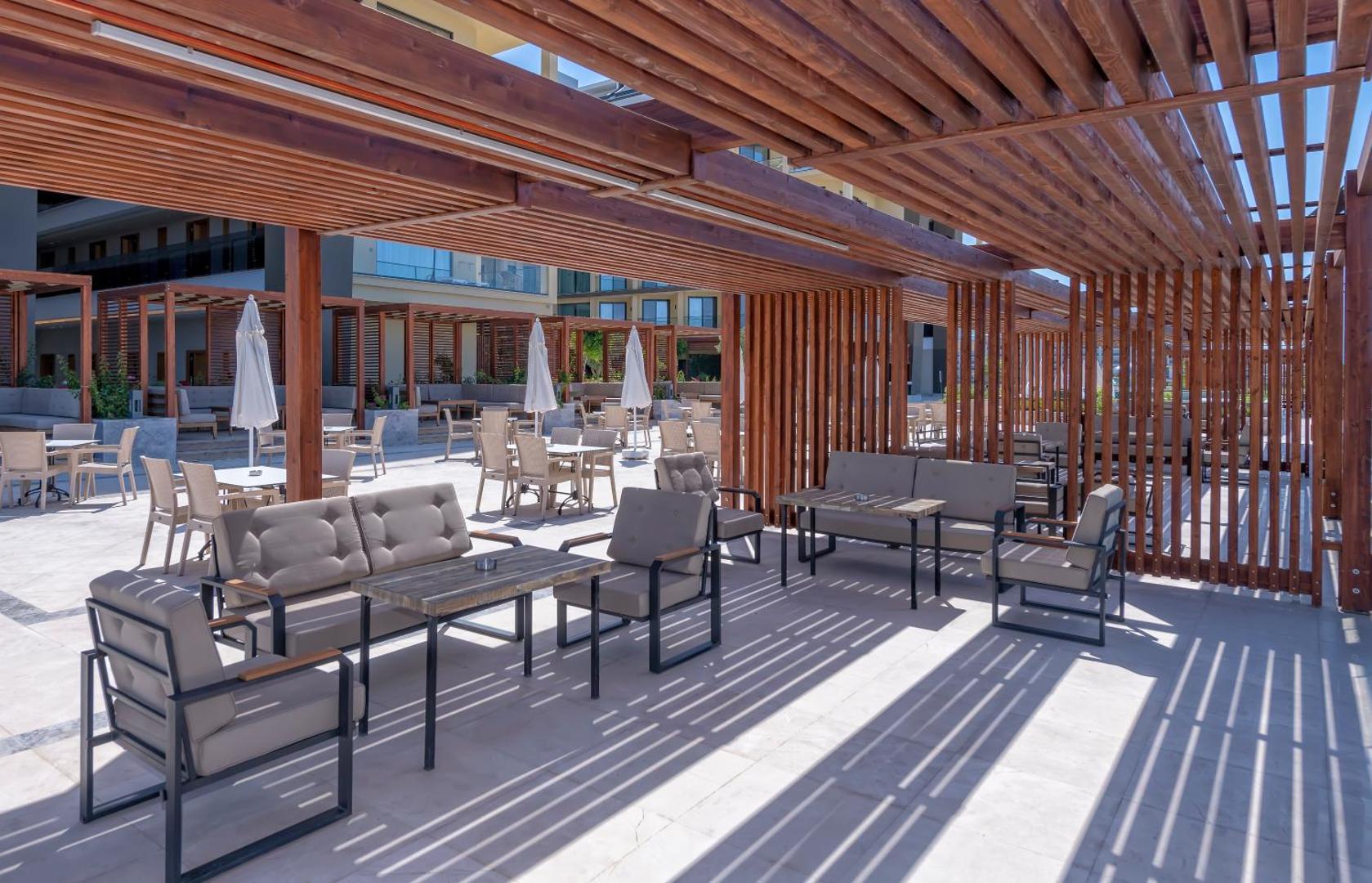 Sorgun Akadia Hotel Luxury āra terase ar koka pergolu, ērtiem dīvāniem un atpūtas krēsliem saulainā dienā Turcijā