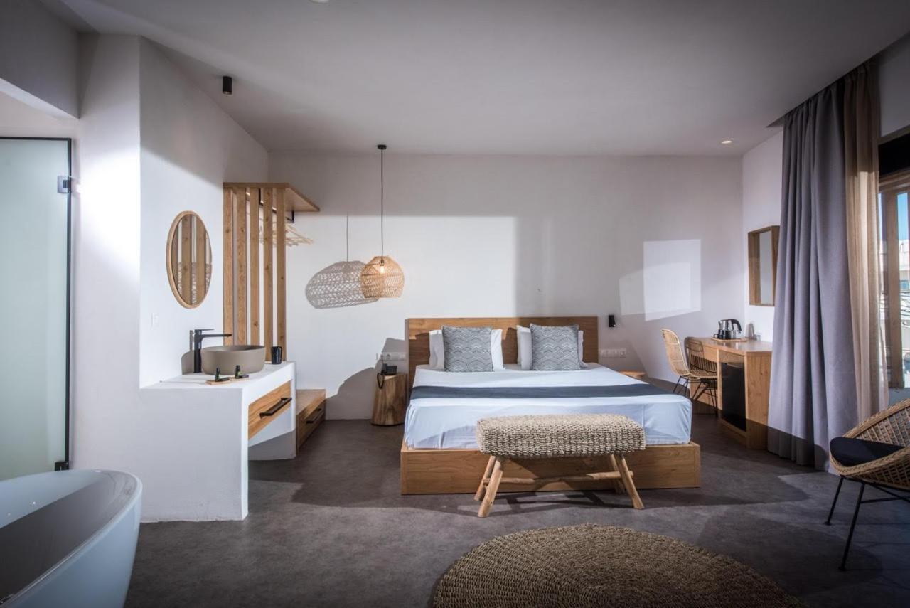 Plašs Indigo Inn Casa viesnīcas numurs ar atvērtā plānojuma vannas istabu, koka mēbelēm un minimālisma stilu Krētā