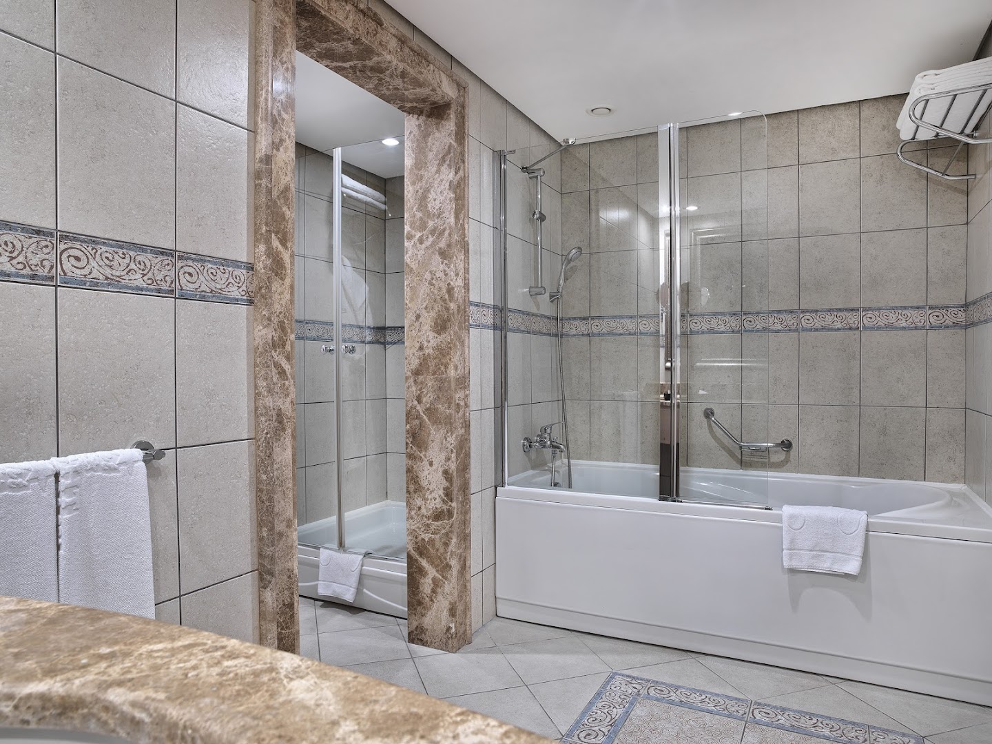 Starlight Resort viesnīcas numura vannas istaba ar gaišām flīzēm, vannu un atsevišķu dušas zonu
