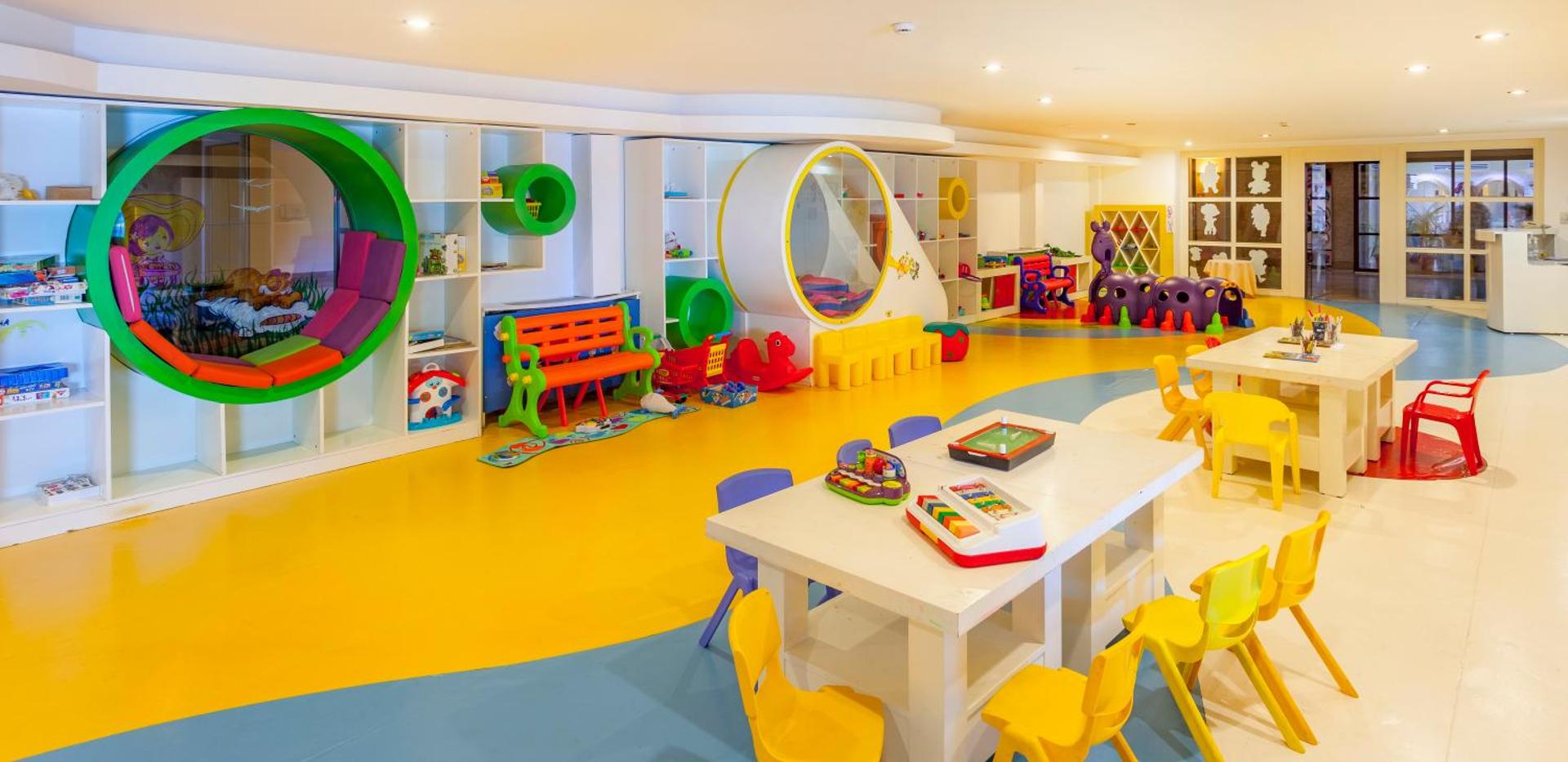 Starlight Resort plašā iekštelpu bērnu rotaļu istaba ar krāsainām mēbelēm, radošiem galdiem un spēļu zonām bērnu izklaidei