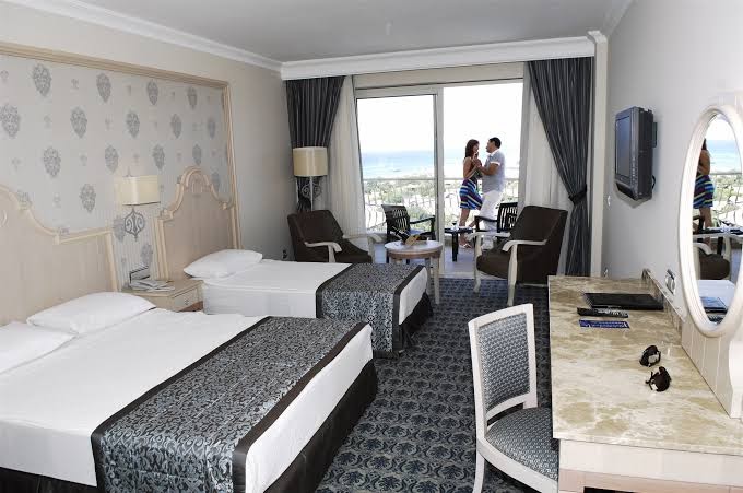 Plašs Starlight Resort numurs ar trim gultām, atpūtas zonu un skatu uz jūru caur lielajiem balkona logiem