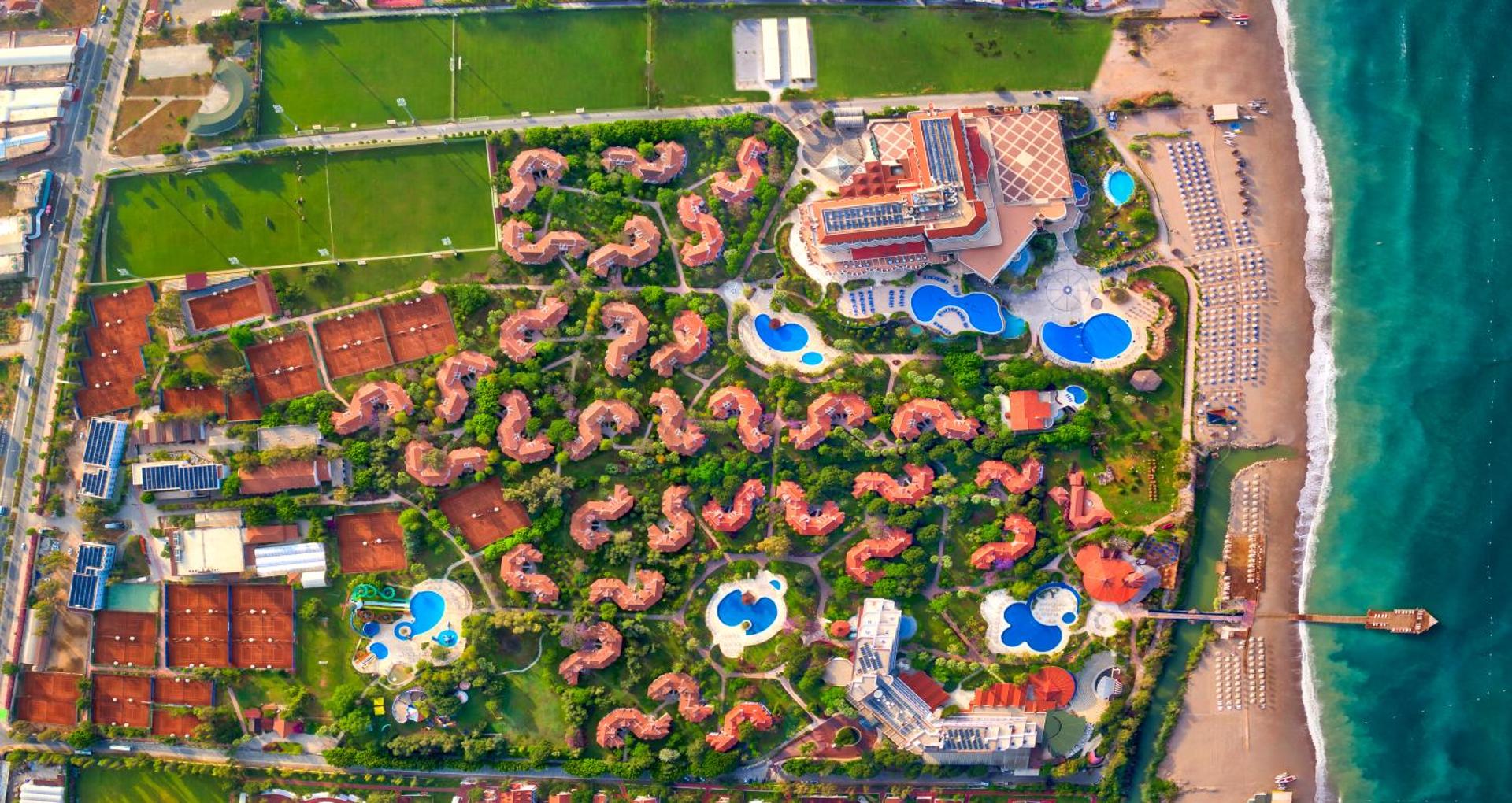 Starlight Resort viesnīcas teritorijas skats no putna lidojuma Sidē — redzami baseini, bungalo kompleksi, tenisa korti un privātā pludmale
