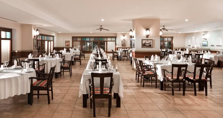 Starlight Resort a la carte restorāns ar eleganti klātiem galdiem, tumša koka krēsliem un klasisku interjeru vakariņām Sides reģionā