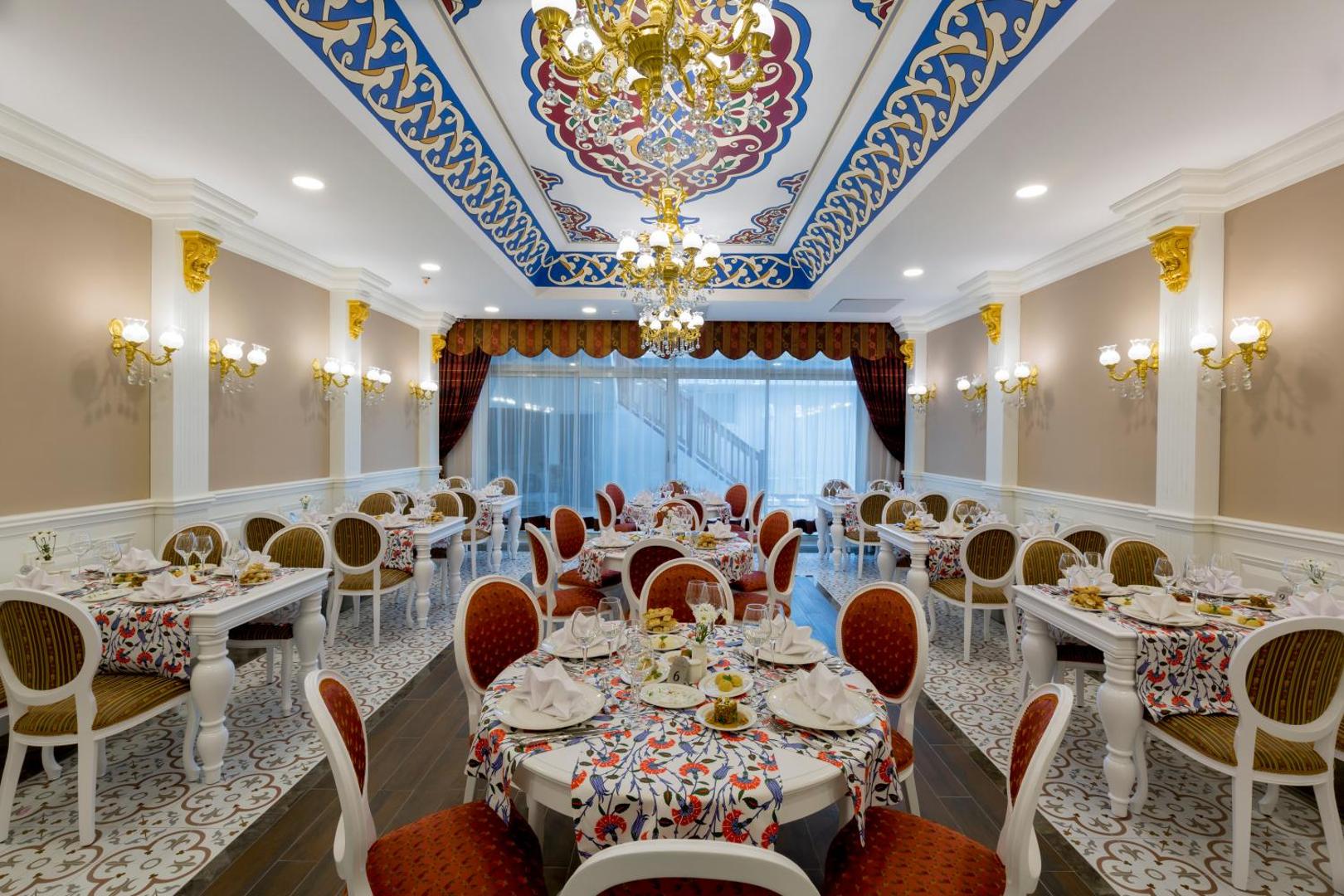 Side Royal Palace a la carte restorāns ar greznu griestu dekoru, lustrām un tradicionāliem rakstiem Turcijas kūrortā