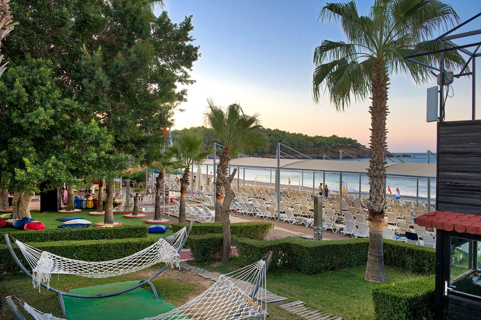 Sealife Buket Resort & Beach atpūtas zona ar šūpuļtīkliem zaļā zālienā pie pludmales Alānijā