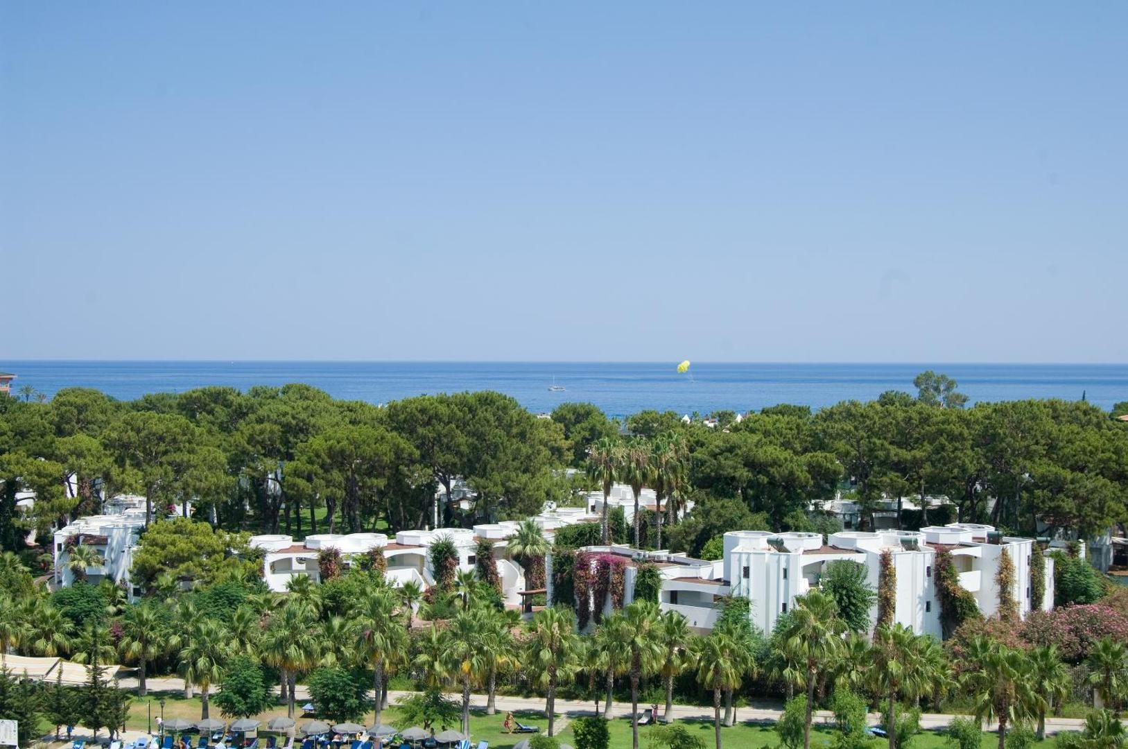 Emelda Sun Club panorāmas skats uz bungalo tipa numuriem, zaļojošu dārzu un zilo Vidusjūru Kemeras piekrastē, Turcijā