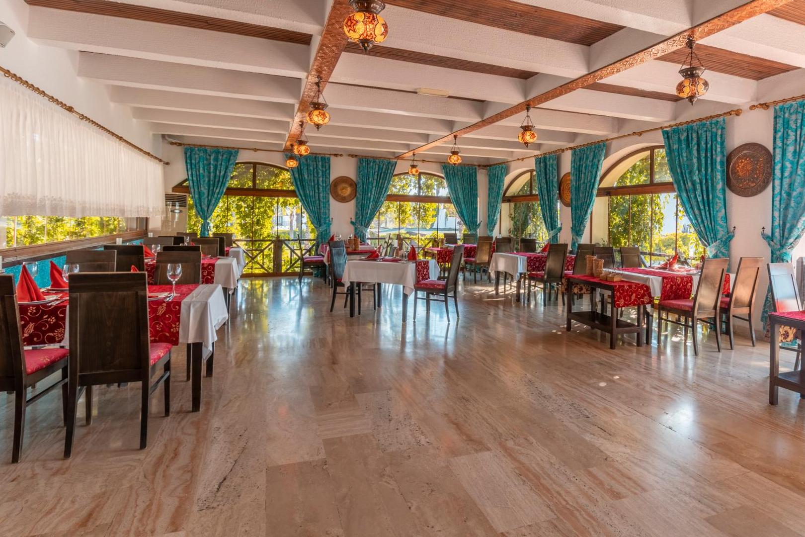 Emelda Sun Club restorāns ar tradicionāliem turku stila gaismekļiem, koka sijām un skatu uz dārzu